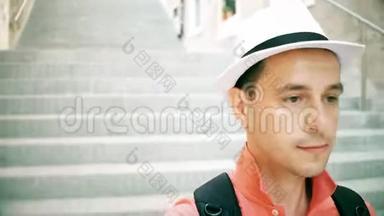 戴着帽子的男旅行者走在楼下的街道上